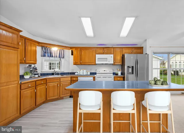 a kitchen with stainless steel appliances granite countertop wooden cabinets a dining table and chairs