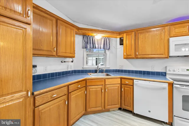a kitchen with stainless steel appliances granite countertop white cabinets sink and a granite counter top