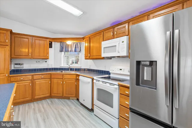 a kitchen with stainless steel appliances granite countertop a refrigerator sink and microwave