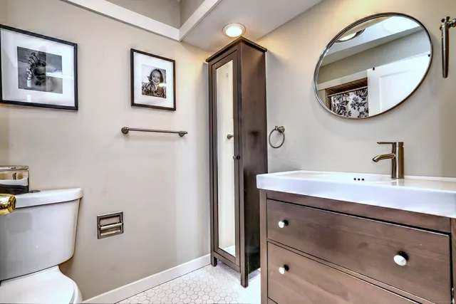 a bathroom with a toilet a sink and a mirror