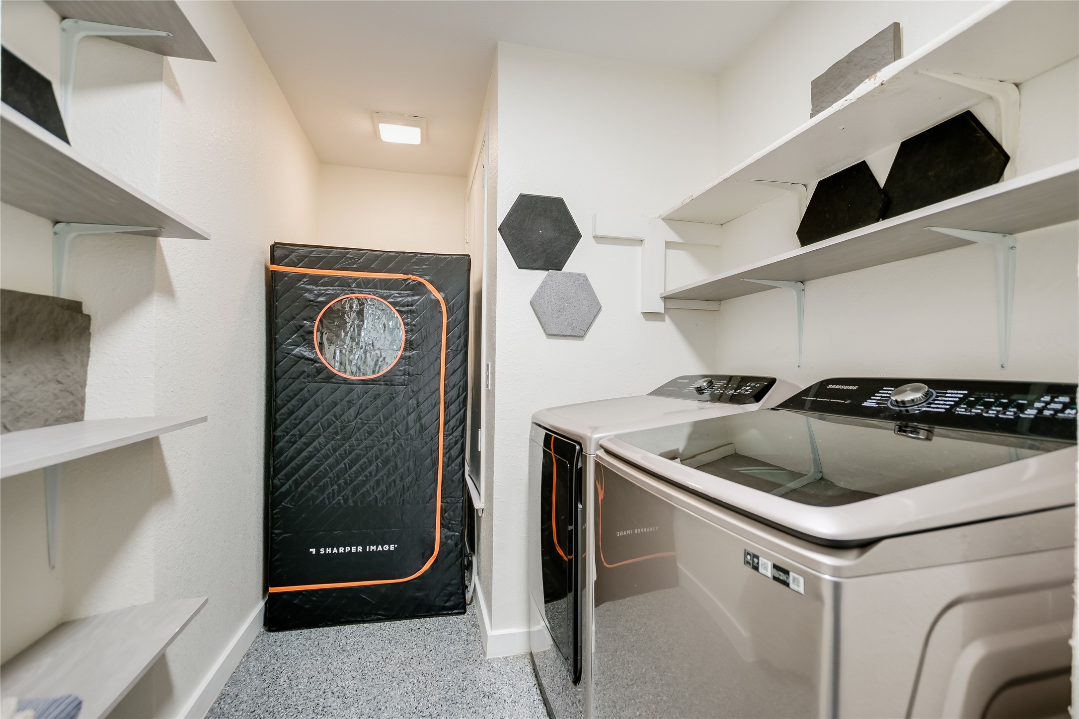 4702 Crest Oak Road Austin, TX 78744 - Photo 9 of 20 Utility room featuring a washer and dryer, epoxy flooring, and built-in shelving