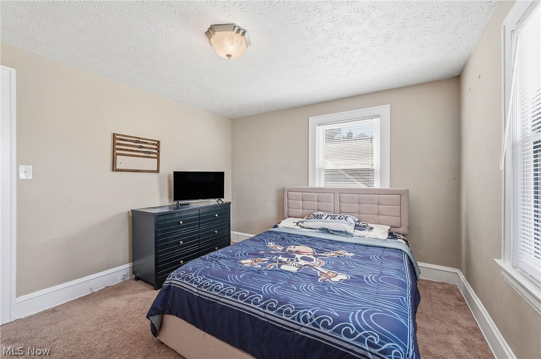 3386 Sylvanhurst Road Cleveland Heights, OH 44112 - Photo 21 of 46 Carpeted room featuring neutral wall paint, a ceiling-mounted light fixture, white trim, and two windows with blinds