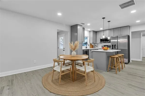 a kitchen with a dining table chairs and refrigerator