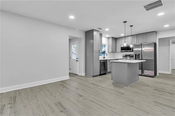 a kitchen with stainless steel appliances granite countertop a refrigerator a sink a stove and a refrigerator