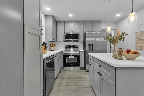 a kitchen with kitchen island white cabinets stainless steel appliances and sink
