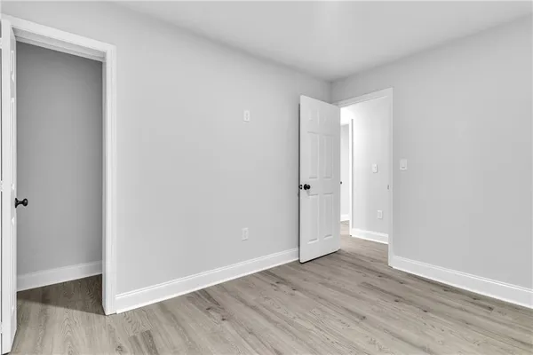 a view of an empty room with wooden floor