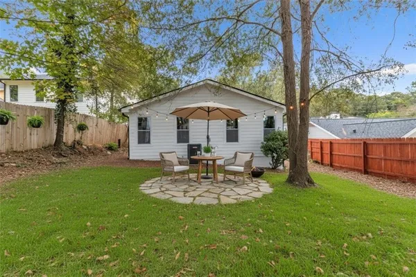 a view of a house with a yard and large tree