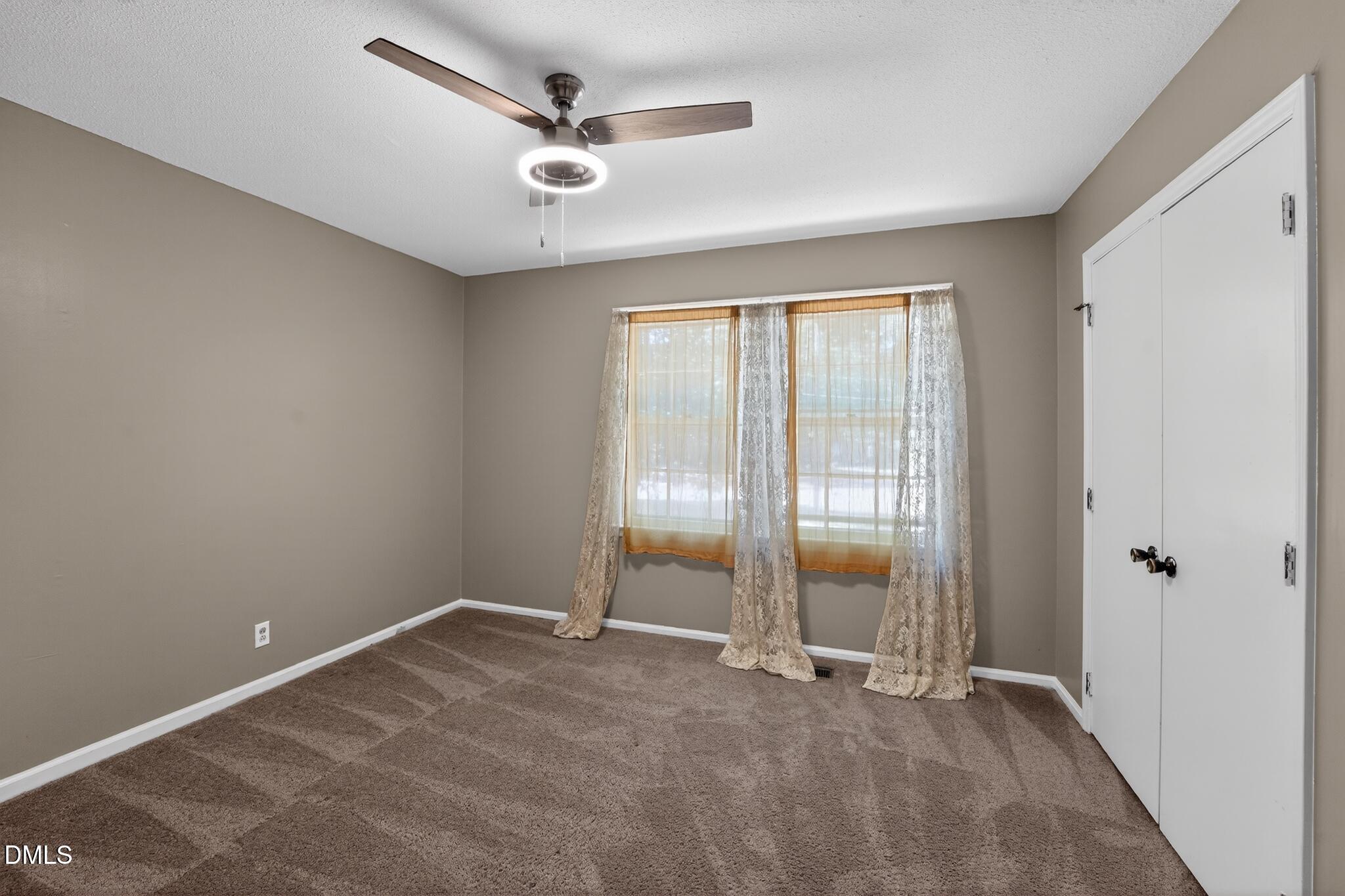 1034 Jerome Road Durham, NC 27713 - Photo 26 of 35 an empty room with window and a ceiling fan