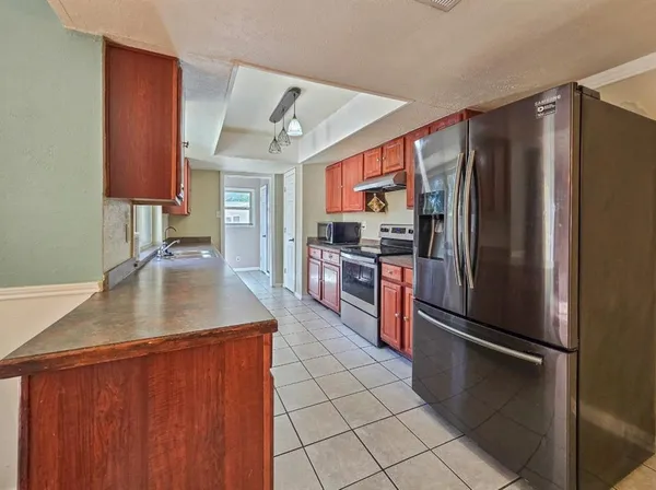 a kitchen with stainless steel appliances granite countertop a refrigerator a sink and a stove