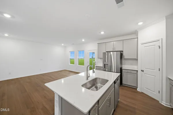 a kitchen with stainless steel appliances granite countertop a sink and a refrigerator