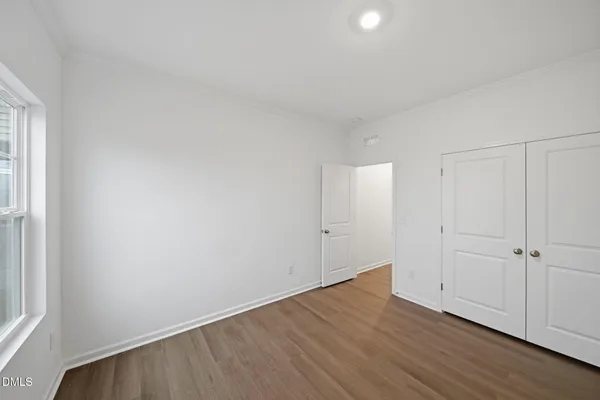 an empty room with wooden floor and closet