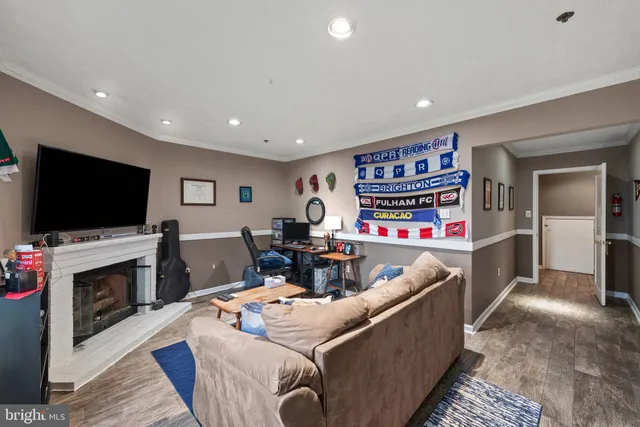 a living room with furniture a flat screen tv and a fireplace