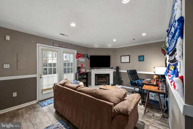 a living room with furniture a flat screen tv and a window