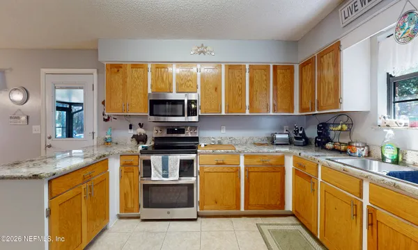 a kitchen with stainless steel appliances granite countertop wooden cabinets a stove top oven a sink and dishwasher