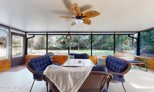 a living room with furniture and a floor to ceiling window