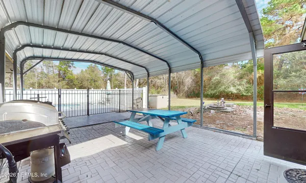 a view of a patio with table and chairs potted plants with wooden floor and fence