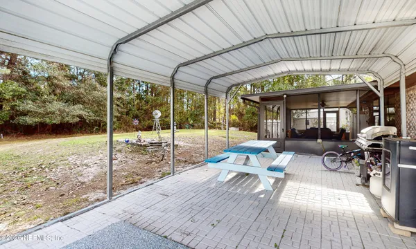 a view of a chair and table in backyard of the house