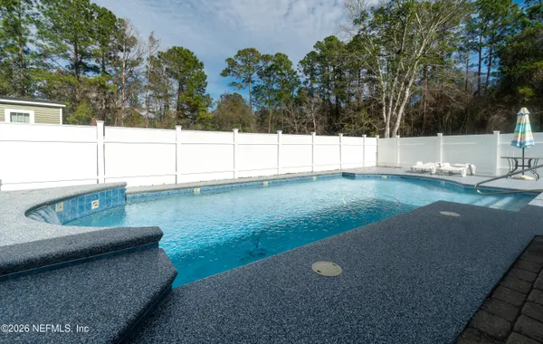 a aerial view of a house with swimming pool and large trees