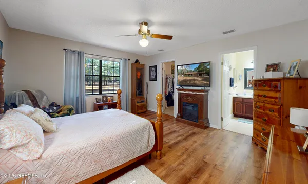 a bedroom with a bed and wooden floor