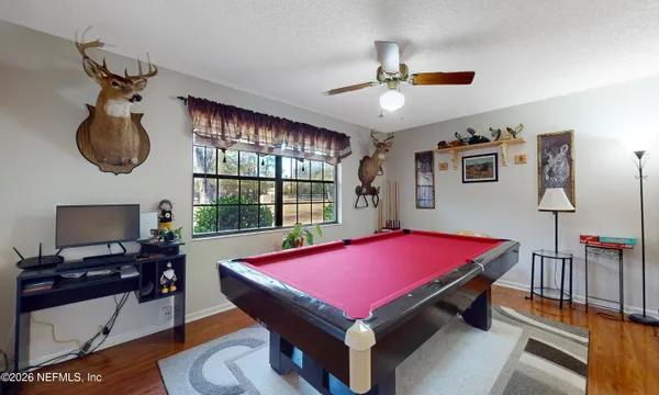a room with pool table and windows