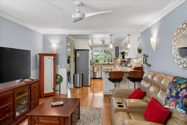 a living room with furniture a clock on wall and a window