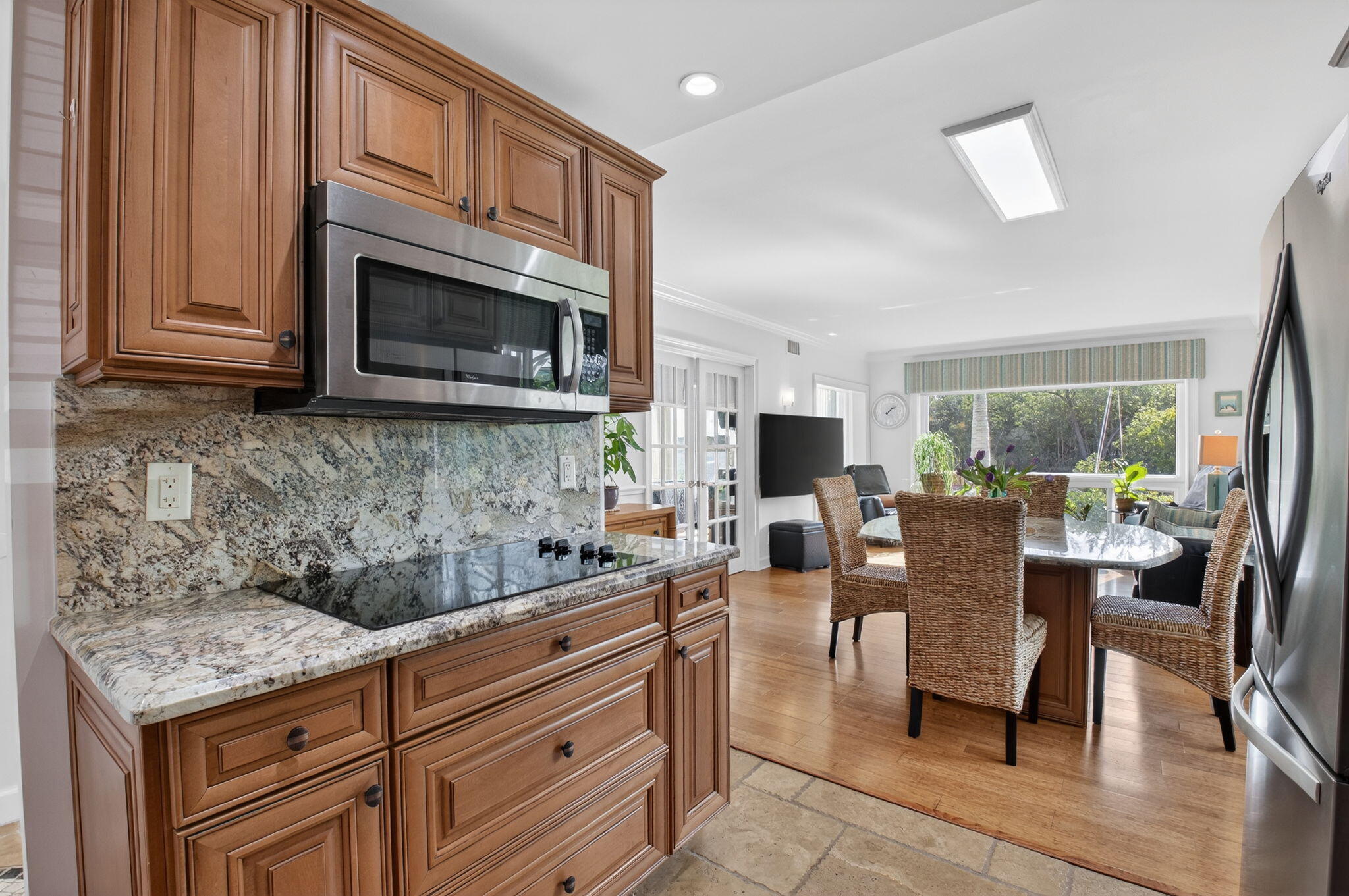 711 Northeast Harbour Terrace, Unit 3120 Boca Raton, FL 33431 - Photo 6 of 46 a kitchen with a stove a sink a microwave a dining table and chairs
