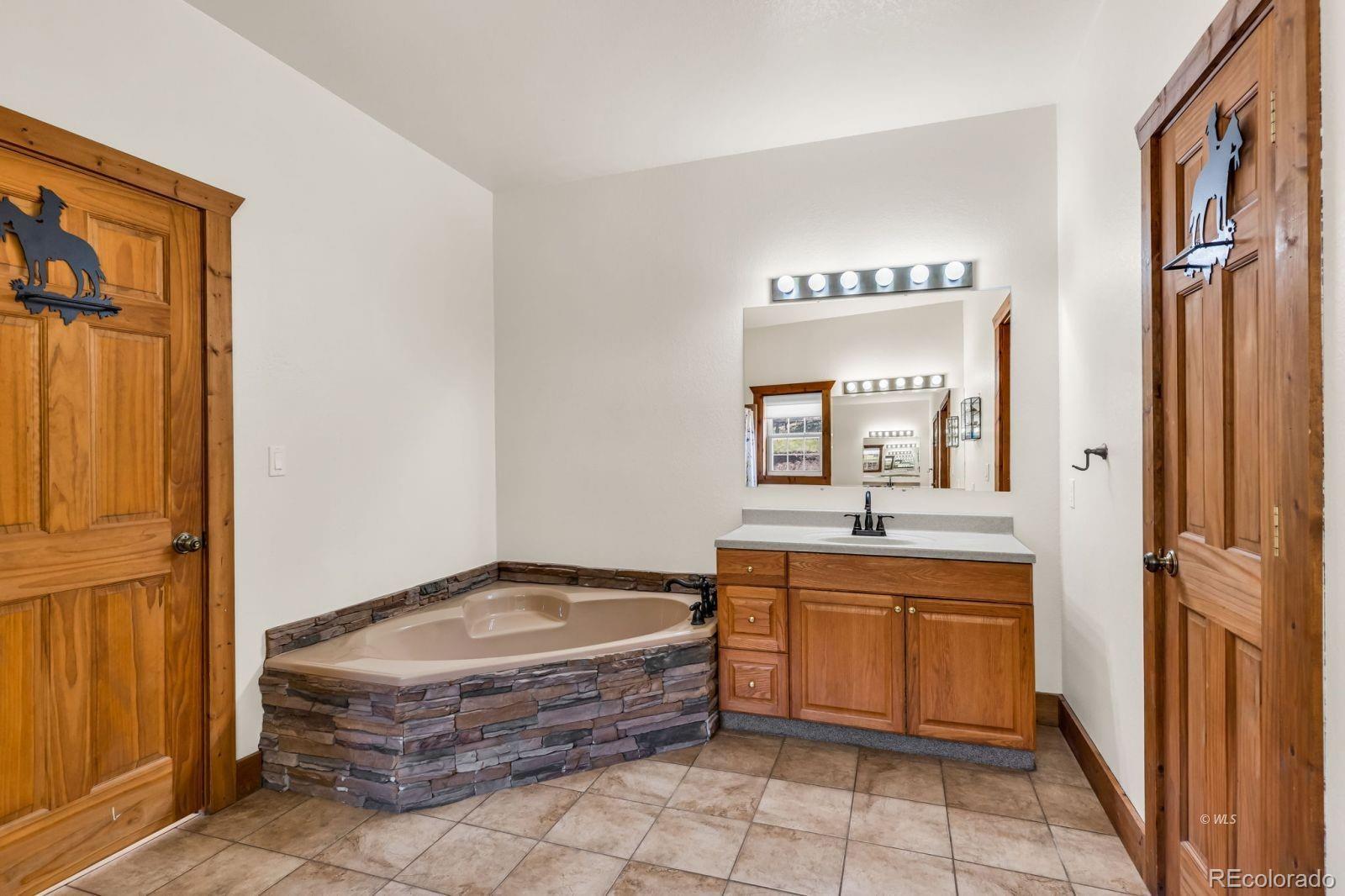220 Rhonda Road Westcliffe, CO 81252 - Photo 15 of 35 a spacious bathroom with a granite countertop sink a mirror and a bathtub