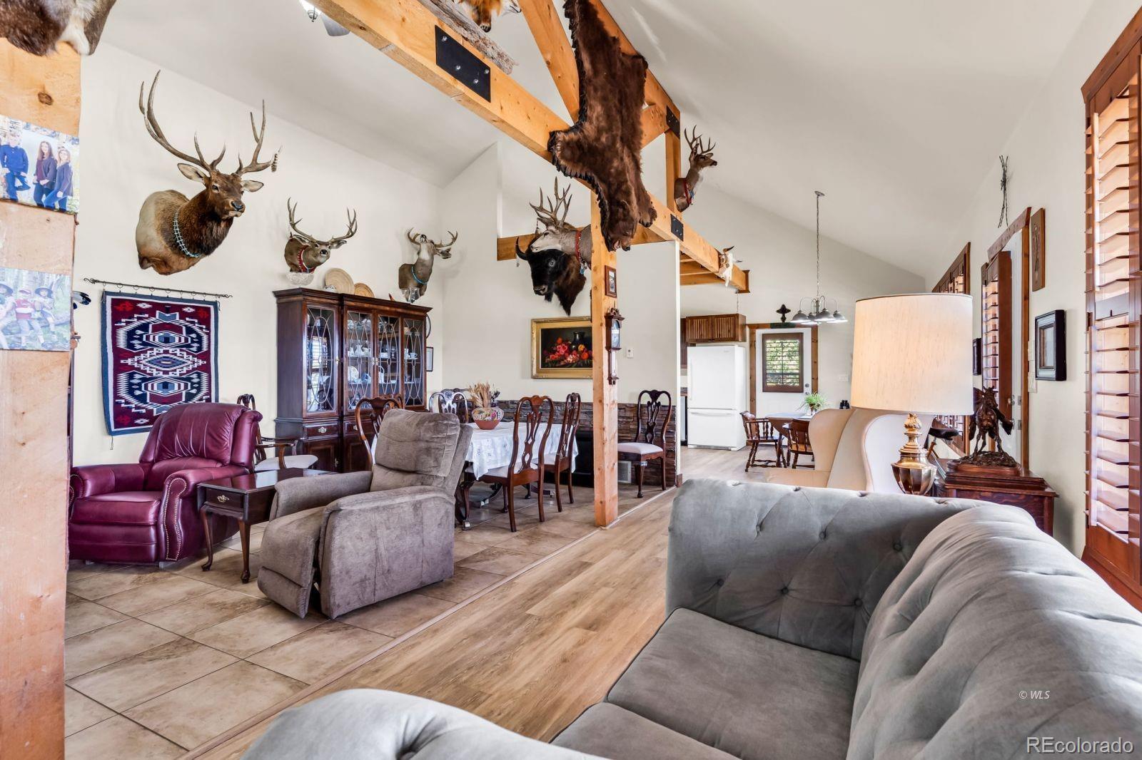 220 Rhonda Road Westcliffe, CO 81252 - Photo 6 of 35 a living room with furniture a chandelier and a fireplace
