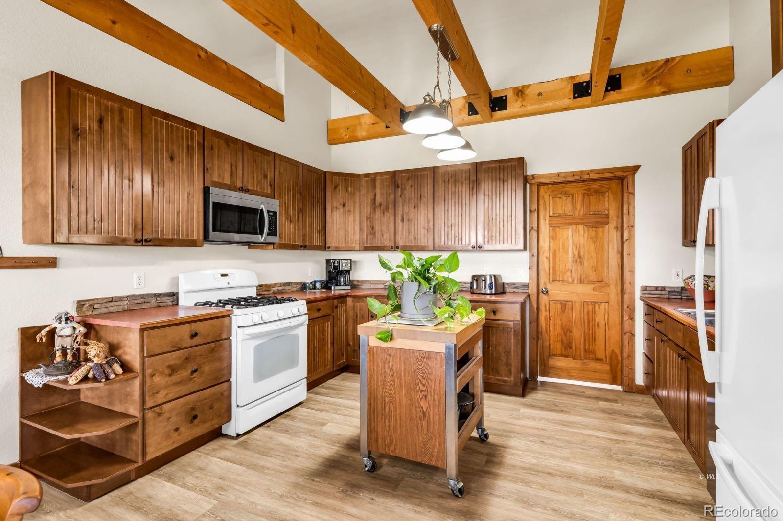 220 Rhonda Road Westcliffe, CO 81252 - Photo 9 of 35 a kitchen with stainless steel appliances granite countertop a stove top oven a sink dishwasher and a refrigerator with wooden floor