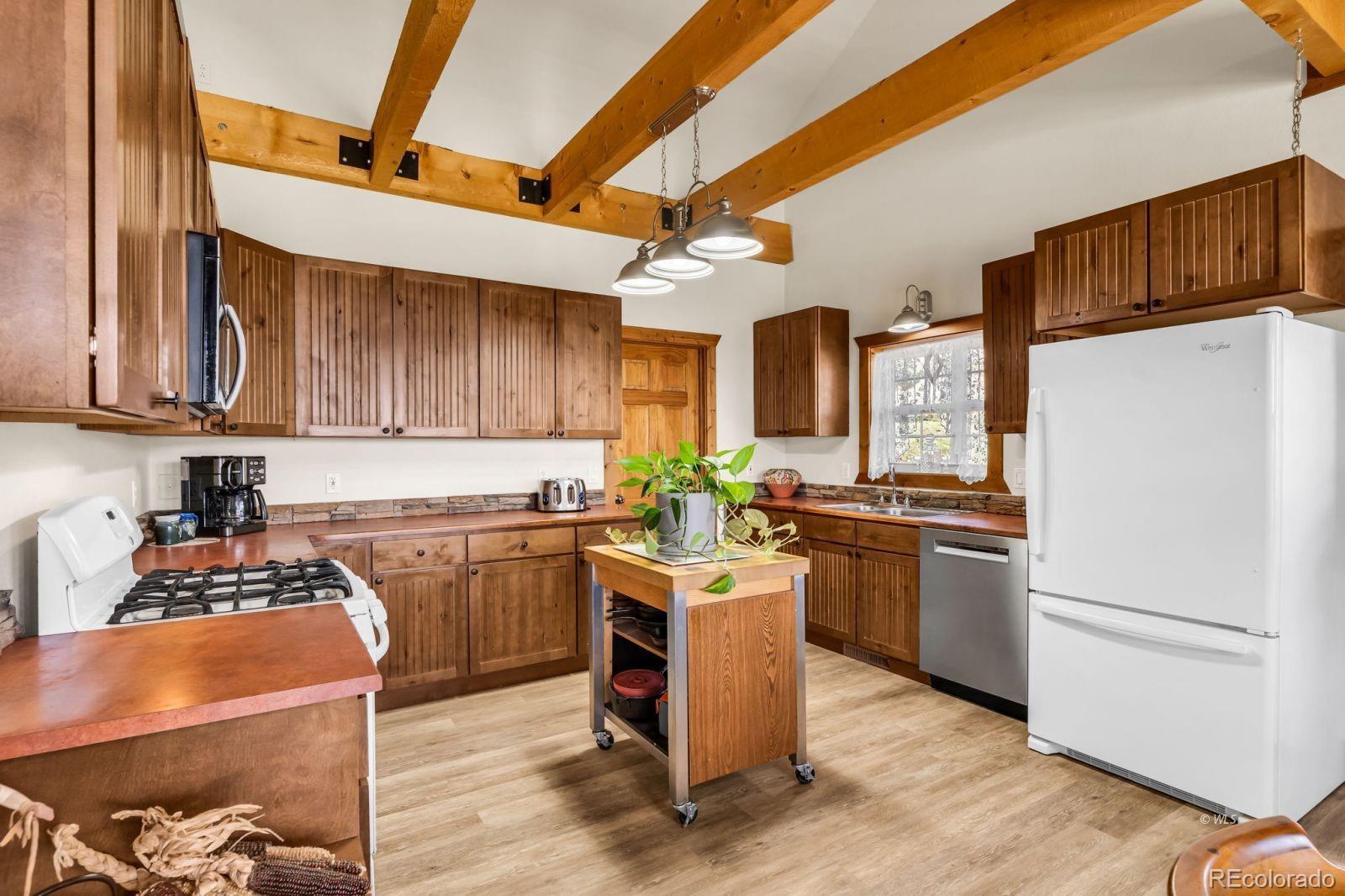 220 Rhonda Road Westcliffe, CO 81252 - Photo 10 of 35 a kitchen with a refrigerator a stove top oven a sink and dishwasher