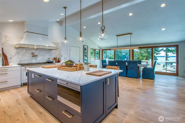 a kitchen with stainless steel appliances granite countertop a stove and a large window