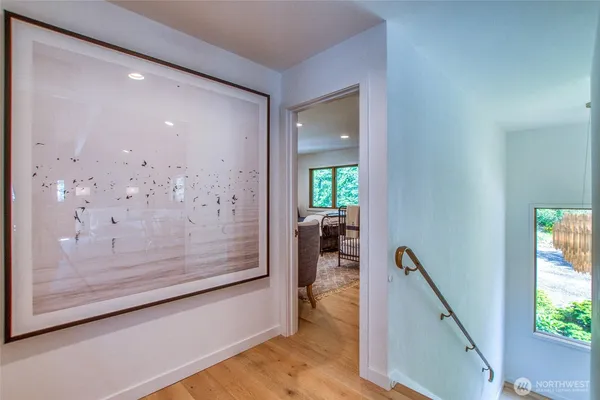 a view of a hallway with wooden floor and a living room