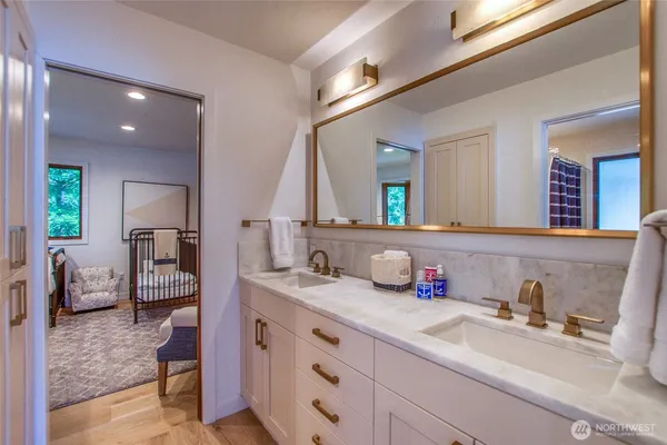 a en suite bathroom with a granite countertop sink and a mirror