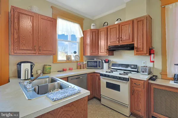 a kitchen with stainless steel appliances granite countertop a sink a stove and cabinets