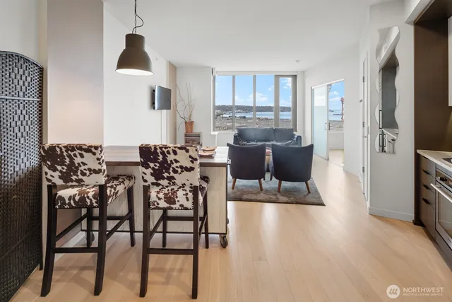 a kitchen with stainless steel appliances a sink a stove a refrigerator cabinets and a dining table