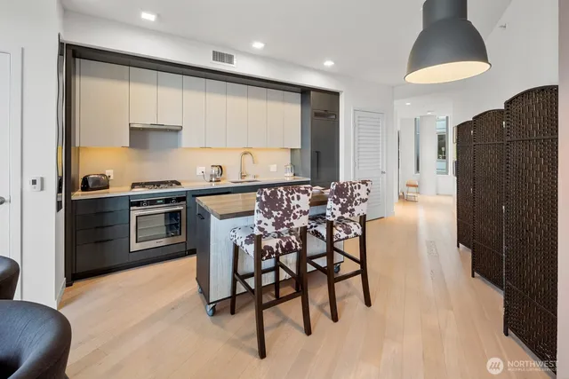 a kitchen with kitchen island granite countertop wooden cabinets and a stove