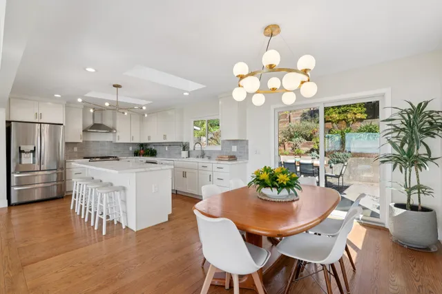 a kitchen with kitchen island granite countertop a dining table and chairs