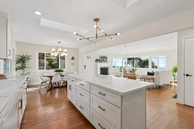 a large white kitchen with lots of counter space dining table and chairs