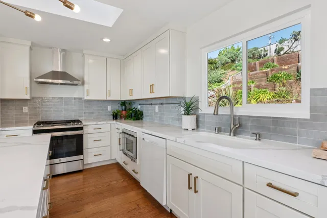 a kitchen with granite countertop white cabinets and white stainless steel appliances