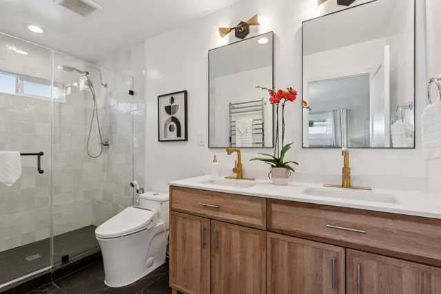 a bathroom with a double vanity sink mirror and toilet
