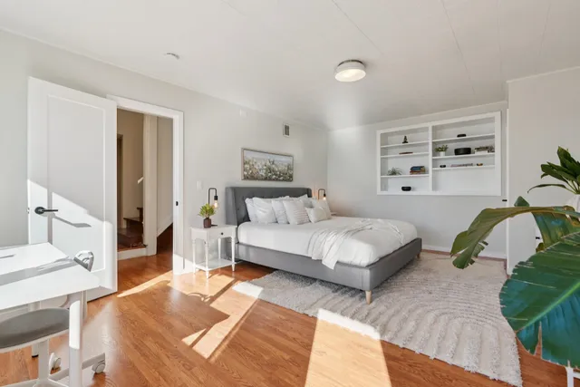 a spacious bedroom with a bed a couch and dresser