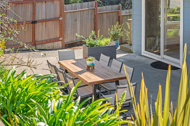a view of a backyard with table and chairs and potted plants