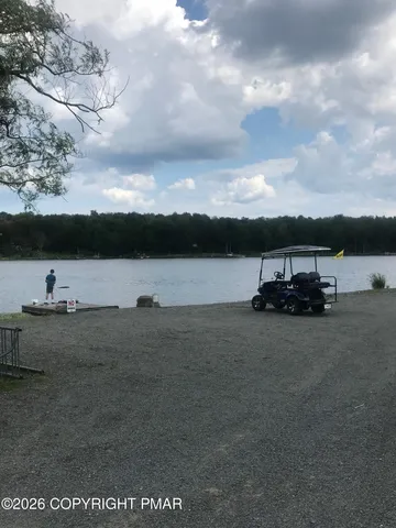 a view of a swimming pool with a table & chairs