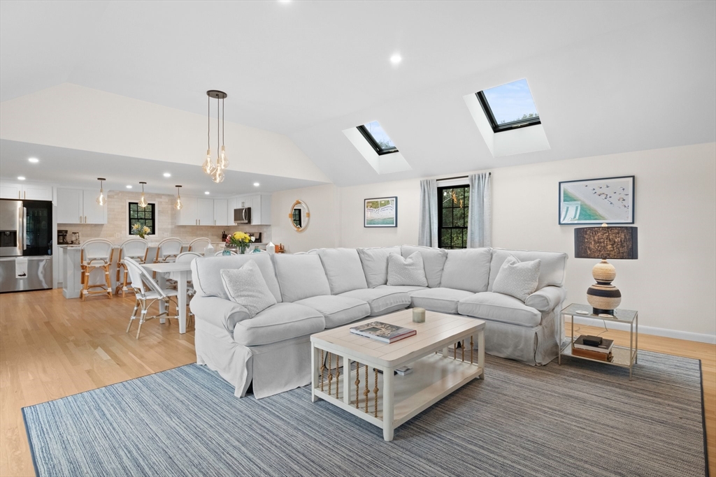 101 Monomoyic Way Chatham, MA 02633 - Photo 2 of 18 a living room with furniture kitchen view and a wooden floor