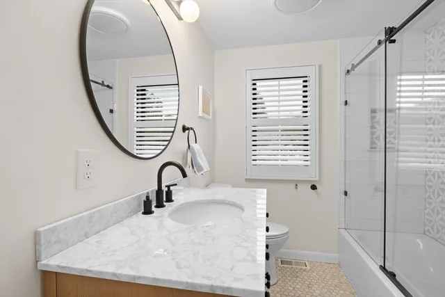 a bathroom with a sink a toilet and a mirror