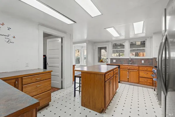 a kitchen with stainless steel appliances granite countertop a sink and a refrigerator