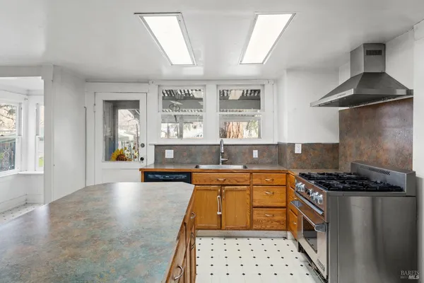 a kitchen with stainless steel appliances a stove a sink and a refrigerator