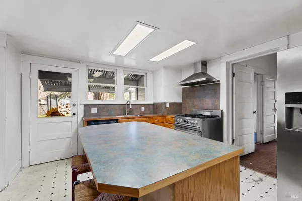 a kitchen with stainless steel appliances a stove a refrigerator and a sink