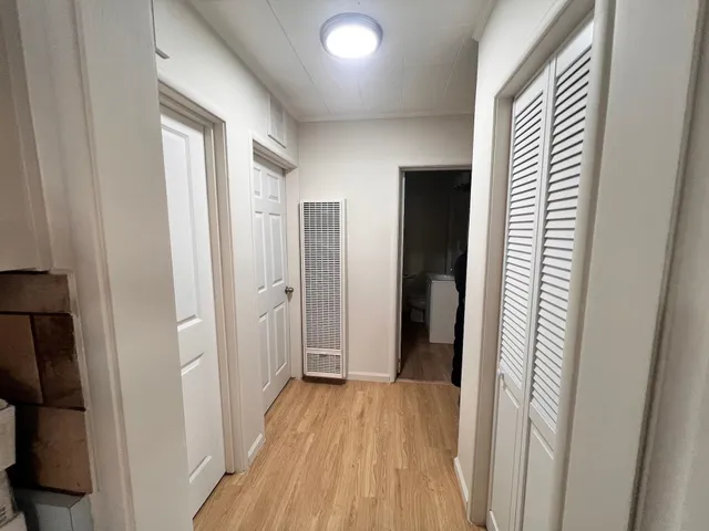 a view of a hallway with wooden floor and staircase