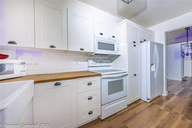 a kitchen with stainless steel appliances white cabinets and a refrigerator